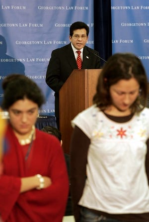 Members of the audience stand up and turn their backs on Attorney General Alberto Gonzales, rear, as he speaks at Georgetown University law school on Tuesday.