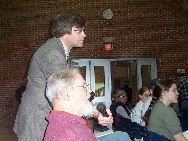 Exeter resident Bartlett Harvey asks a question at a Saturday forum for candidates running for New Hampshire's First U.S. Congressional District seat. The forum was held at the University of New Hampshire. Portsmouth activist and forum moderator Peter Somssich holds the microphone.
