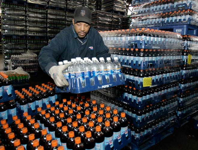 Jory Sears stacks PepsiCo products on a pallet Tuesday in preparation for shipping at Pepsi America, a distributor of Pepsi products in Cleveland. PepsiCo Inc. reports a 13 percent increase in its fourth-quarter earnings.