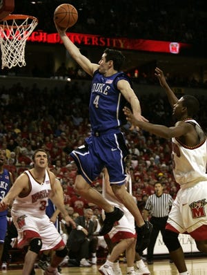 Duke's J.J. Redick, center, drives by Maryland's D.J. Strawberry and Will Bowers, left, on his way to the basket.