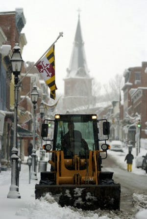 A worker plows snow along Main Street in Annapolis, Md., on Sunday. A major storm slammed the mid-Atlantic and Northeast states with nearly 2 feet of snow.
