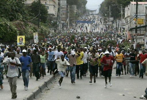 Hundreds of supporters of Haitian presidential front-runner Rene Preval run down Delmas Road to join more protesters in Port-au-Prince, Haiti, on Monday.