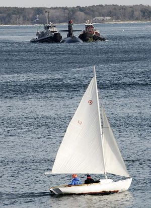 A SAILBOAT STEERS CLEAR of an oncoming submarine Wednesday afternoon, as the sub, escorted by two tugboats, heads into the Portsmouth Naval Shipyard through Portsmouth Harbor.