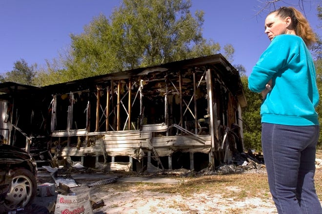 Peggy Rose Munoz stands outside of the damaged remains of her home, which was set on fire last week, in Summerfield on Monday. "Now I don't have a car or home," said Munoz, who lived there with three of her children.