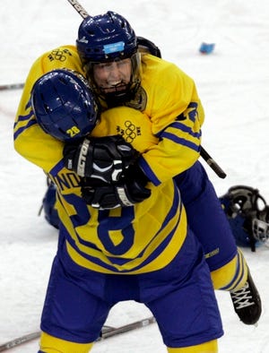 Sweden's Danijela Rundqvist (28) and Jenny Lindqvist embrace after beating the United States in a shootout.