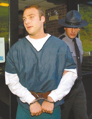 Pennsylvania State police escort Hugo Selenski from his court appearance Oct. 6, 2003, in Kingston, Pa. Nearly three years ago, a tip led police to a remote northeastern Pennsylvania hillside where they made a gruesome discovery: five sets of human remains buried in the backyard of a convicted bank robber. On Tuesday, Selenski is to go on trial for killing two of the five.