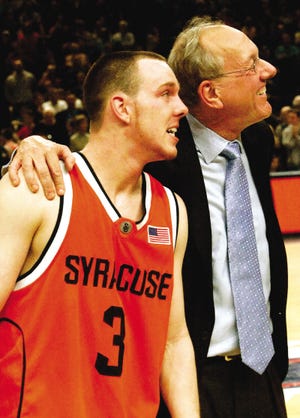 Syracuse guard Gerry McNamara (3) looks at the scoreboard with head coach Jim Boeheim after beating top-ranked Connecticut 86-84 in overtime in a quarterfinal round game of the Big East Men's Basketball Championship Thursday at New York's Madison Square Garden.