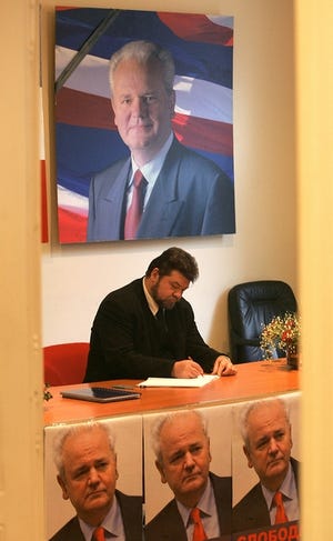 Slobodan Milosevic’s longtime head of office, Goran Milinovic, signs a book of condolences in the headquarters of the pro-Milosevic support group “Free-dom" in Belgrade on Sunday.
