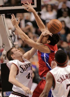 Detroit Pistons' Carlos Delfino, of Argentina, is guarded by Philadelphia 76ers' Shavlik Randolph (42) as Sixers' John Salmons (7) watches in the first half of an NBA basketball game Wednesday, March 29, 2006, in Philadelphia. (AP Photo/George Widman)