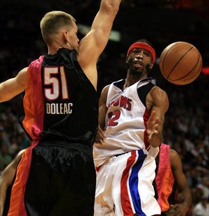 Detroit guard Richard Hamilton passes the ball past Miami's Michael Doleac to Ben Wallace in the first period Thursday in Miami.