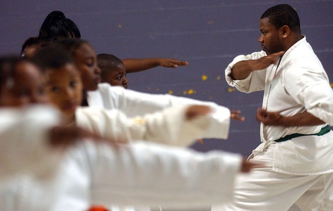 Assistant instructor Devon Johnson-Jones demonstrates punches for students of the Golden Dove Martial Arts Ministry class Thursday at the McDonald Hughes Center. The class is a Christian martial arts class that incorporates Scripture with the martial arts lessons.