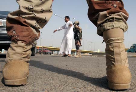 Iraqi soldiers check civilians for weapons at a checkpoint in Baghdad Sunday. Bombs and drive-by shootings killed nine people in Iraq on Sunday, and the bodies of seven Iraqi men who apparently had been kidnapped and tortured in captivity were found in three different areas of Baghdad, police said. AP photo