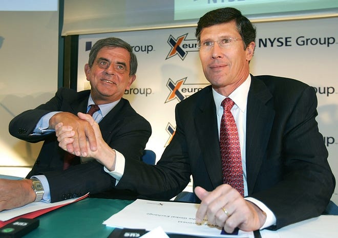 NYSE Euronext company chief executive officer John Thain, right, shakes hand with, deputy chief executive officer Jean-Francois Theodore during a news conference held in Paris Friday. The NYSE agreed on Thursday to buy Euronext for US$9.96 billion in cash and stock.