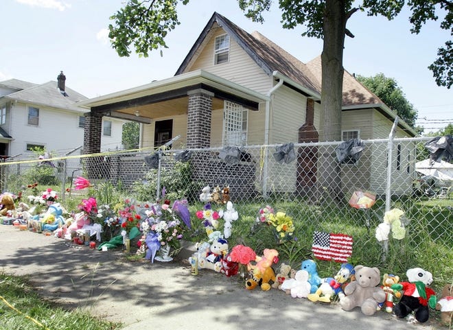 Flowers and teddy bears appear at the Indianapolis home where a family was slain.