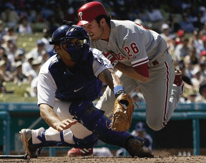 Philadelphia Phillies' Chase Utley, right, knocks over Los Angeles Dodgers catcher Russell Martin at home plate in the eighth inning in Los Angeles on Sunday. Utley was safe at home and the Phillies won 6-4.