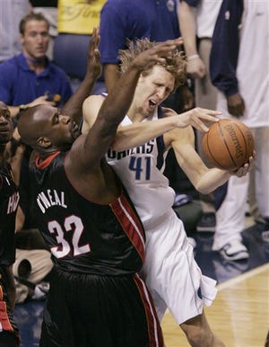 Dallas Mavericks' Dirk Nowitzki (41) of Germany is fouled by Miami Heat's Shaquille O'Neal (32) in the first quarter in Game 2 of the NBA basketball finals in Dallas, Sunday, June 11, 2006.
