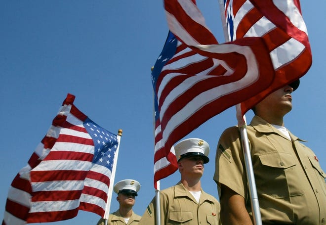 Students from the Marine Corps Air Station at Cherry Point present variations of the U.S. flag that have existed throughout history at a Flag Day ceremony in New Bern, N.C., on Sunday.