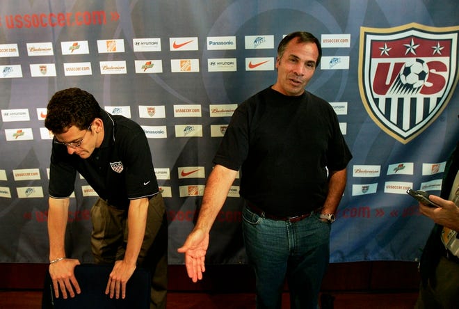 United States coach Bruce Arena, right, speaks to journalists at a news conference in Hamburg, Germany, on Friday as press officer Michael Kammarman listens at left. The United States lost to Ghana, 2-1, on Thursday and was eliminated from the World Cup.