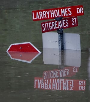 Water covers signs on a street named for boxer Larry Holmes in Easton Pa., Thursday. Easton is Holmes' hometown.