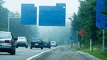 Blue-tarped signs face southbound traffic on Route 3 near the Sagamore Rotary. The covers will disappear this fall when the rotary will be replaced by the flyover.