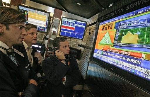 Employees of KV Execution services watch a television screen in their boot on the floor of the New York Stock Exchange, Thursday June 29, 2006, as the interst rate decision of the Federal Reserve is announced. The Federal Reserve on Thursday raised a key interest rate -- by a quarter-point to 5.25 percent-- for the 17th consecutive time and signaled that further rate hikes may still be needed to fight inflation.