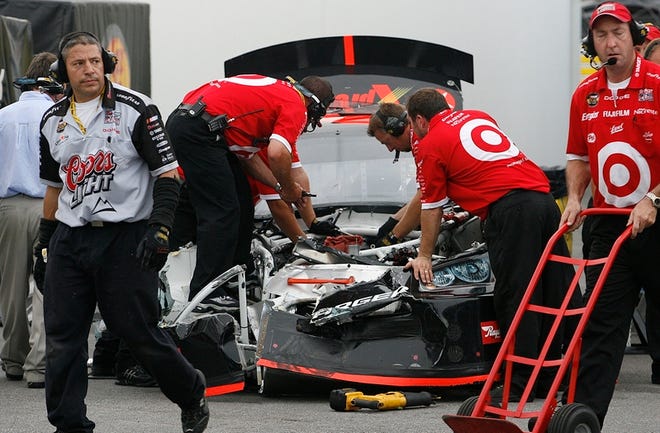 Casey Mears' crew works on his wrecked car Thursday in Daytona Beach after he crashed into Jeff Burton's car, forcing both into backup cars during the final practice session.