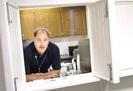 Matt Davis, director of Merrimack River Medical Services, stands behind the medication window where patients may be treated for their addictions at the newly opened Newington facility.