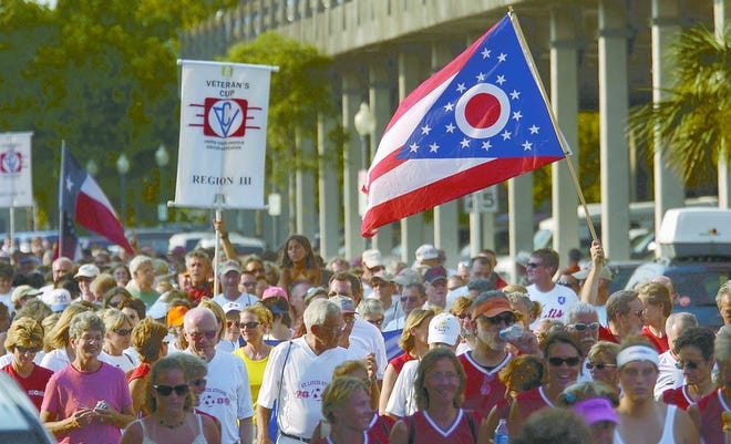 A participant waves a flag from the state of Ohio as a parade of soccer players proceeds up Water Street on Tuesday evening. Nearly 100 teams have geared up in Wilmington for the 2006 U.S. Amateur Soccer
Association’s Veterans Cup, one of the largest soccer tournaments in the country.