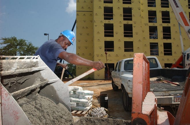 Anthony Brown of Tuscaloosa-based Level Masonry mixes concrete in front of the construction site for the Hilton Garden Inn near the intersection of Alabama Highway 69 and Interstate 20/59.