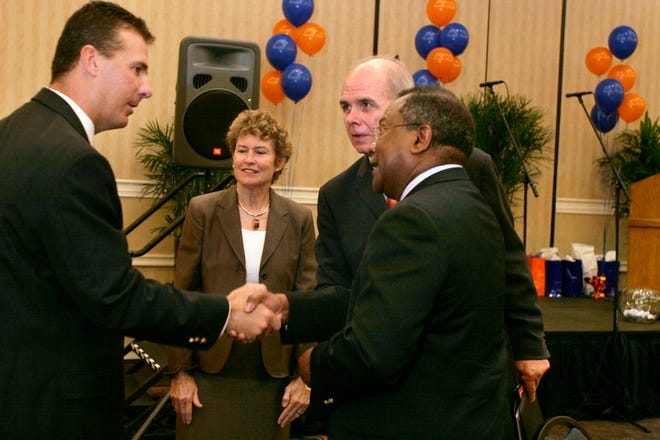 University of Florida football coach Urban Meyer, left, greets UF trustee Roland Daniels, along with UF first lady Chris Machen and President Bernie Machen before the start of the Joint Civic Club Luncheon.