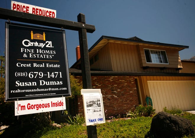 A "priced reduced" sign tops an advertisement for an existing home in Los Angeles on Wednesday. Sales of previously owned homes plunged in July to the lowest level in 2 years, and the inventory of unsold homes climbed to a new record high, fresh signs the housing market has lost steam.