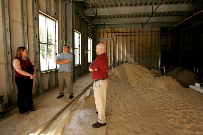Standing inside what will be Gainesville's first true wine bar are, from left, Staccie Allen, Bob Mitrione and Chris Allen. A wooden bar will anchor the far wall and doors will open along the exterior wall, at left, to allow outdoor seating.