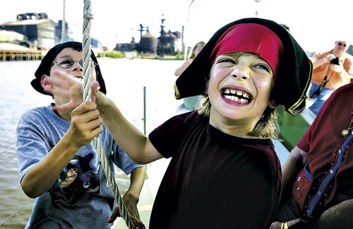 From left, Nicholas Faile, 10, of Rock Hill, South Carolina, and Nathan Habetz, of Fairfield, Connecticut, race with other junior pirates to get the sails up at the beginning of the voyage.
