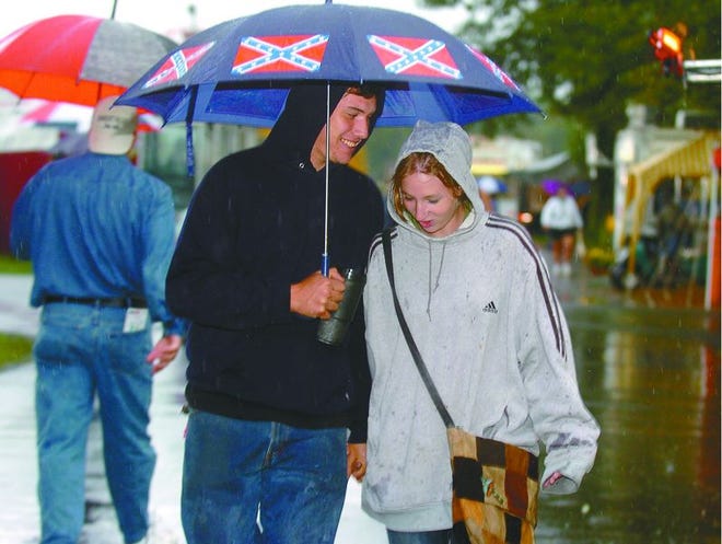 Zach Anthony, 17. and Kathy Raffensperger, 17, both of Kunkletown, take a break from their jobs on opening day at the West End Fair on Sunday for a stroll in the rain. Anthony has never missed a West End Fair and the soggy weather didn’t keep him or hundreds of other faithful fairgoers away.