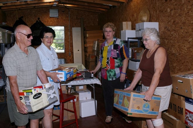 Lester Pynn, Madeline Pynn, Kathy Medina and Diana Harris bring in books for the Friends of the Forest Library book sale which will be held on Saturday.