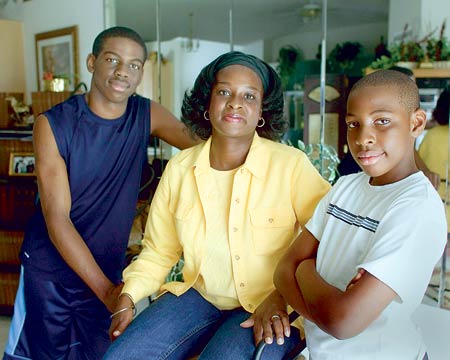 Lisa Davis con sus hijos Raymond, 16, izquierda, y Jason, 10, a quienes ella dicta clases y asignaturas escolares en su casa en Davenport.