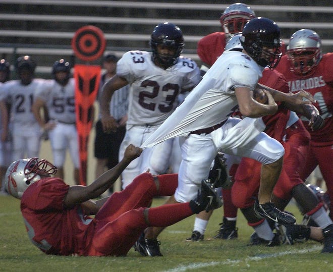 Benedictine quarterback A.J.DeFilippis escapes a tackle in first half-action aganist Jenkins High School.