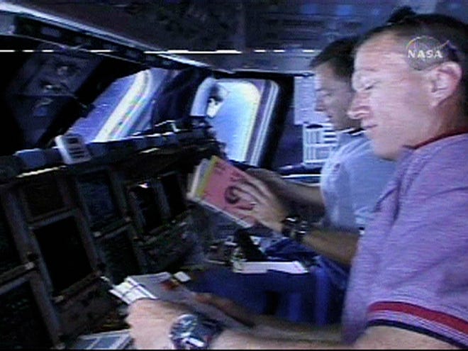 STS-115 pilot Chris Ferguson, left, and commander Brent Jett prepare to perform a reaction control system jet maneuver on the flight deck of the space shuttle Atlantis on Sunday in this view from television.
