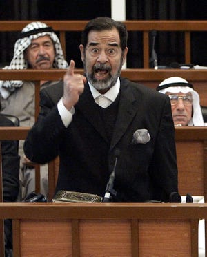 Former Iraqi president Saddam Hussein points as he testifies during his trial in the fortified Green Zone in Baghdad, Iraq, on Monday.