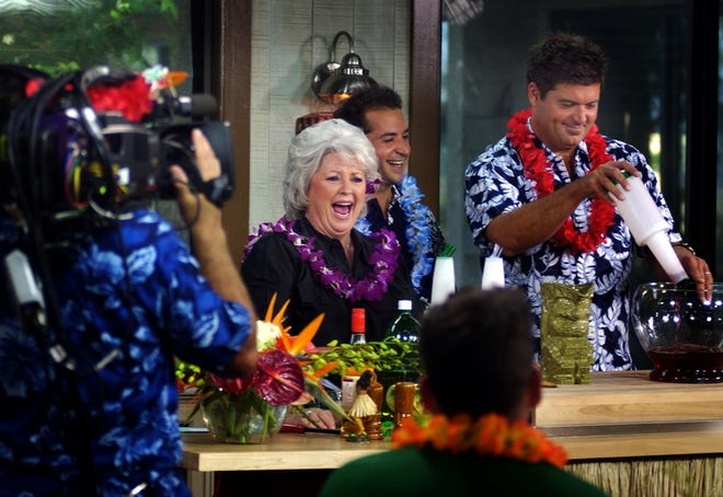 Paula Deen, center, and her sons Jamie, right, and Bobby, rear, tape her show in Savannah, Ga. Cable TV's queen of Southern-fried comfort food is still coming to grips with the Paula-mania that's seized Savannah since her Food Network show took off in 2002.