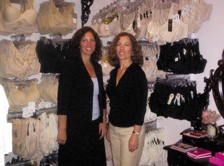 Deborah Robb, left, and Deanna Tinios stand next to some of the items offered in their lingerie store, Top Drawer, in Exeter.