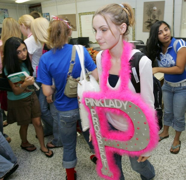 Freshman Amanda Wesolowski, 13, wears her Pink Lady Prospect banner at Vanguard High School on her way to a Pink Lady club meeting earlier this month. Members of the Pink Ladies say the group is more than just a club; it is a way to interact with the community and with others who share similar interests and concerns.