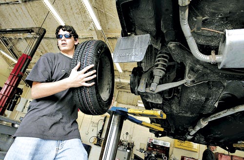Rickey Robinette, 14, of Loften High School, works on the tires of a 1991 Honda Civic wagon in his automotive science techonolgy class Tuesday. New principal Chet Sanders took over in June 2006.
