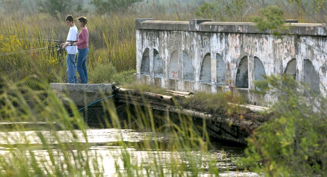 Garret Hurt and his sister, Kristen Nettles, go fishing late Monday afternoon in the Salt Creek off Ogeechee Road.