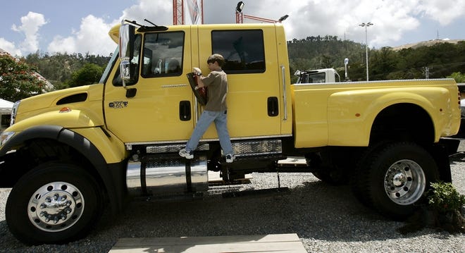 A boy plays on a truck-pickup displayed at the Caracas Auto Show in Venezuela on Saturday.