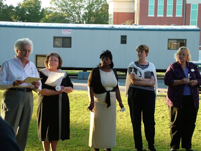 Victim-Witness board chairman Ruth Lee, left, directs an Oct. 3 candlelight vigil held in Springfield for victims of violent crimes. Standing with Lee are, second from left to right, Victim-Witness executive director Glenda King, Victim-Witness employee Ruth Brown and Parent and Child representatives Kathryn Klock-Powell and Connie Terry.