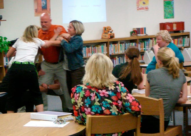 Teachers from Burleson Independent School district's Norwood Elementary participate in a drill called the swarm technique during an August training seminar.