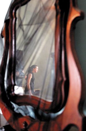 Maryann Rowland, a tour guide at St. Joseph Plantation in Vachrie, is reflected in a cloth covered mirror. Rowland was giving a mourning tour. Covering mirrors was a mourning tradition in south Louisiana.