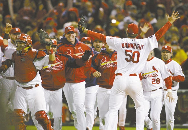 Cardinal players rush towards pitcher Adam Wainwright after beating the Tigers 4-2 in Game 5 to win the World Series four games to one Friday night in St. Louis.