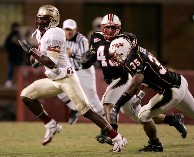 Florida State quarterback Xavier Lee, left, rushes away from Maryland linebackers Rick Costa, center, and Wesley Jefferson, right.
